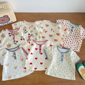 Flat lay of soft cotton gauze baby short sleeve tops featuring cute bear and cherry patterns