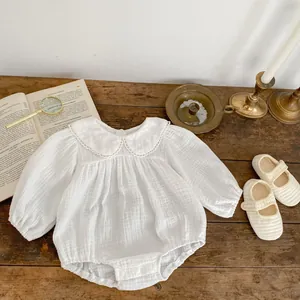 Detail of baby cotton bodysuit with embroidered petal collar and matching soft shoes
