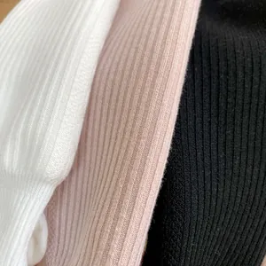 Detailed macro view of ribbed knitted fabric in white, pink, and black winter leggings