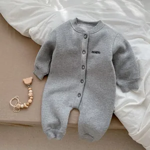 Dettaglio di una tutina neonato in cotone grigio spesso con ricamo BONITO e bottoni