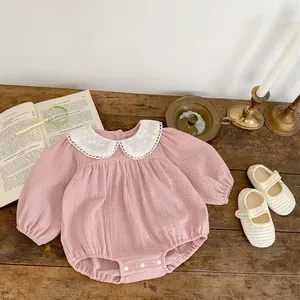 Close-up of pink cotton romper with Peter Pan collar and embroidered lace detail