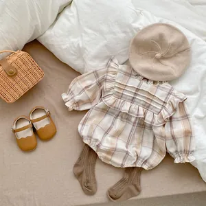 Detailed flat lay of baby plaid romper set with beret, shoes, and decorative mini straw bag