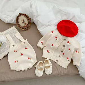 Infant knit set with mushroom embroidery cardigan and romper on a cozy bedding setup