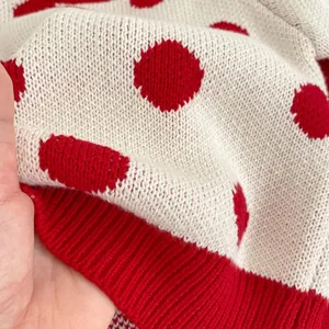 Baby knitwear set featuring white polka dot sweater with red ribbed edges and thick texture