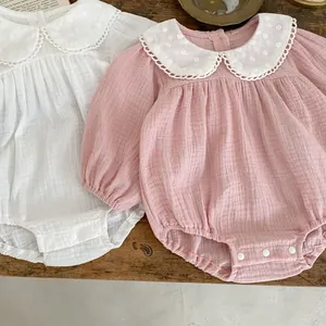 Detailed view of baby romper featuring doll collar with embroidery and snap button closure