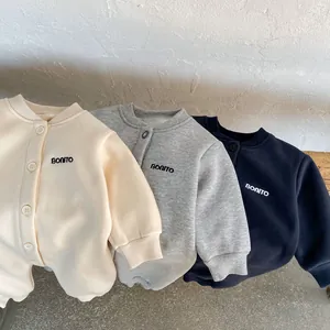 Dettaglio di pagliaccetti in pile per neonati in beige, grigio e blu ricamati