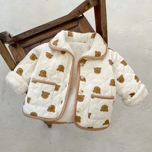 Winter infant quilted jacket with cute bear print and warm fleece lining on a chair