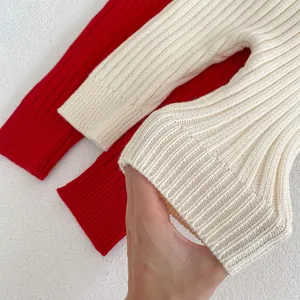 Macro detail of red and cream ribbed knit cuffs showing soft texture and elasticity