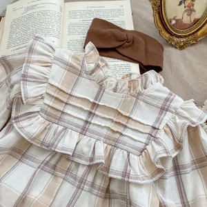 Plaid ruffle baby romper with floral collar and matching brown headband in vintage style