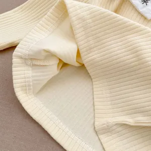 Détail de haut en coton côtelé pour bébé avec ourlet à double couture et étiquette étoile