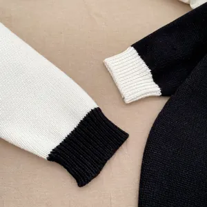 Detail der farbblockierten Baby-Strickjacke mit strukturierten Rippbündchen und dickem Stoff