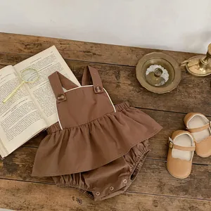 Detail von braunem Baby-Baumwollset mit Retro-Knöpfen auf dunklem Holzuntergrund