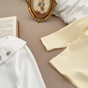 Détail du col Claudine brodé et de la texture en maille côtelée sur les hauts pour bébé