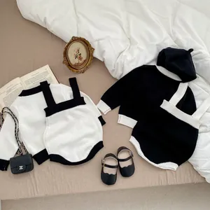 Detail von Baby-Strickset in Schwarz-Weiß mit Langarmshirt und Trägerstrampler