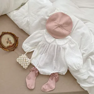 Detailed view of baby white Peter Pan collar romper with pink beret and bow socks
