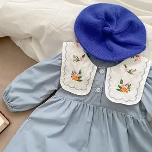Close-up of baby girl blue cotton dress with large white floral embroidered collar detail