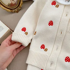 Detail of baby knit cardigan with mushroom embroidery and white Peter Pan collar