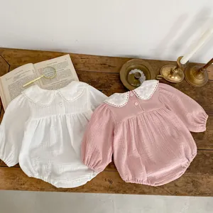Close-up of baby romper featuring white lace Peter Pan collar with floral embroidery details