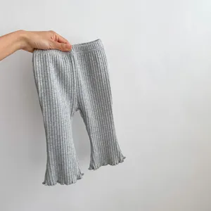 Detail of grey ribbed flared leggings with ruffled hem and elastic waistband for baby girls