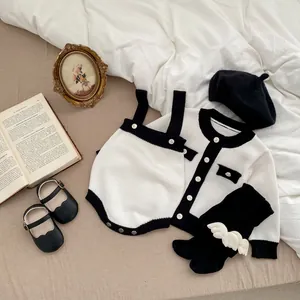Flachbild-Detail eines 5-teiligen schwarz-weißen Baby-Stricksets mit Vintage-Requisiten