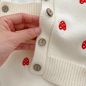 Cream knit baby cardigan with mushroom embroidery and rustic wooden buttons