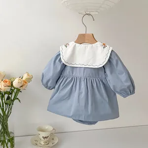 Detail of baby girl bodysuit with floral embroidered white collar and elastic cuffs