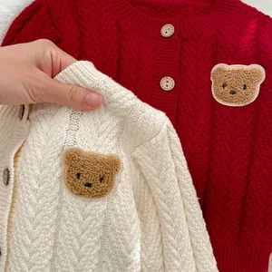 Detail der Zopfstrick-Struktur am Baby-Cardigan mit süßem Bären-Patch und Holzknöpfen