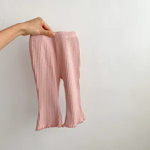 Detailed macro view of pink ribbed knit fabric with delicate lettuce trim on the leg opening