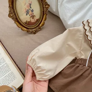 Detailaufnahme der Babybluse mit Rüschenkragen und elastischen Bündchen im Vintage-Stil