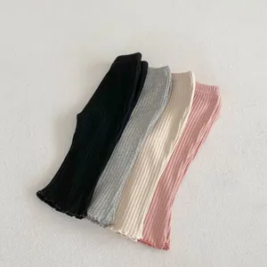Flat lay of four pairs of ribbed baby leggings with ruffle hems in soft pastel colors