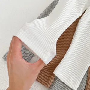Detail of high-elastic ribbed cotton fabric for baby leggings in white, grey, and brown