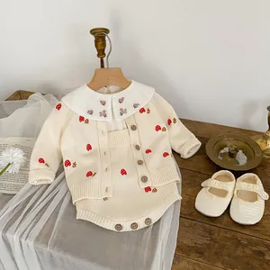 Detail of mushroom embroidery on knit baby cardigan with vintage wooden buttons