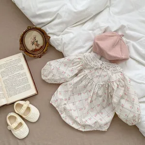 Detail view of baby floral bodysuit featuring a delicate white lace collar and soft cotton fabric