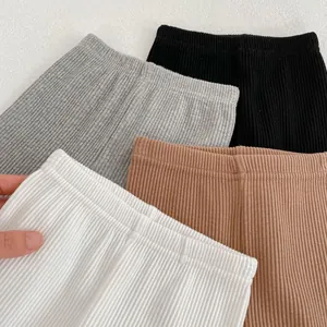 Detail of ribbed knit baby leggings in grey black white and brown cotton fabric