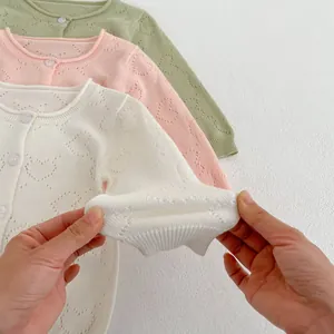 Baby girl heart cutout knit cardigan in cream, pink, and green colors for sun protection