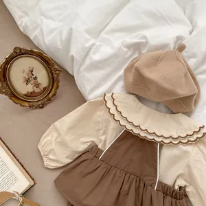 Detailaufnahme von Baby-Vintage-Outfit mit Rüschenkragen und Strick-Baskenmütze