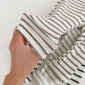 Detailed view of the ribbed knit fabric and neat stitching on striped baby leggings