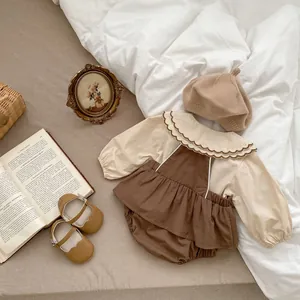 Flachbild von Baby-Rüschenbluse, brauner Trägerhose und Strickmütze im Set