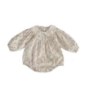 Floral baby bodysuit with lace collar and snap closures on a clean white background