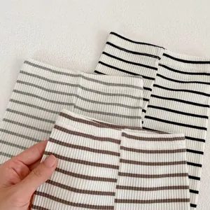 Detailed view of elastic ribbed waistbands on striped cotton leggings for infants