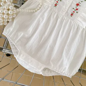 White cotton baby romper with floral embroidery and ruffle details for summer