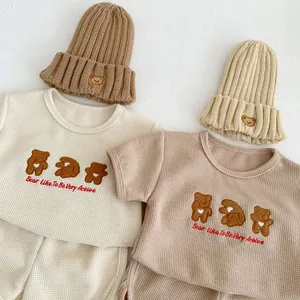 Detail of waffle knit baby set featuring soft cotton fabric and cute bear embroidery