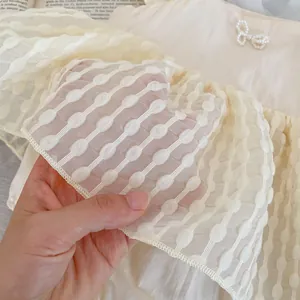 Barboteuse d'été bébé fille avec couches de mesh à pois et accent de nœud en perles