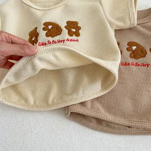 Detail of baby waffle knit tee showing soft texture and cute bear embroidery accents