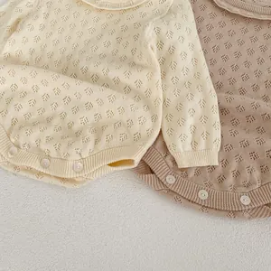 Detail of infant knit rompers in cream and oat colors with hollow point pattern