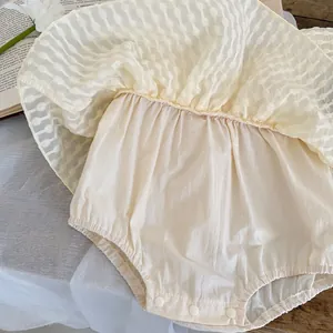 Détail des boutons-pression et de la texture quadrillée sur la jupe en maille