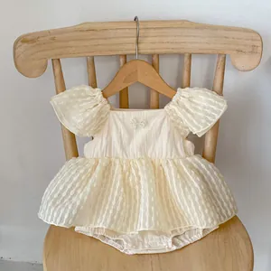Détail d'une barboteuse crème pour bébé fille avec nœud en perles et jupe en tulle