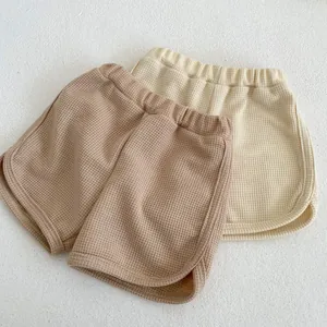 Detailed view of baby waffle knit shorts with elastic waist in beige and khaki colors