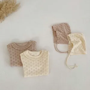 Detailed view of hollow knit texture and ruffled collar on cotton baby rompers