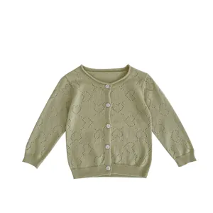 Green knit baby cardigan with heart cutout patterns and white buttons on white background